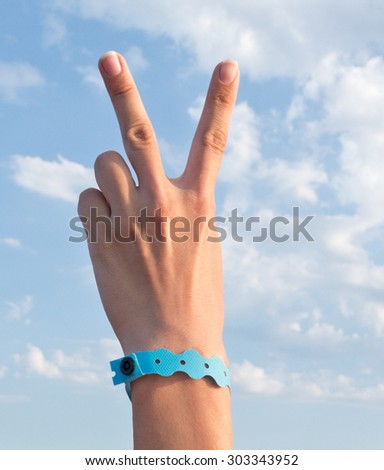 hand with all inclusive bracelet over sea background