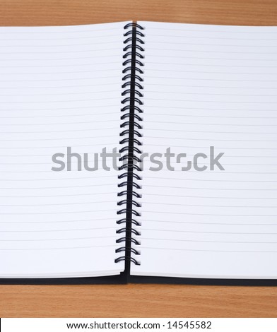 open spiral notebook on a wood table
