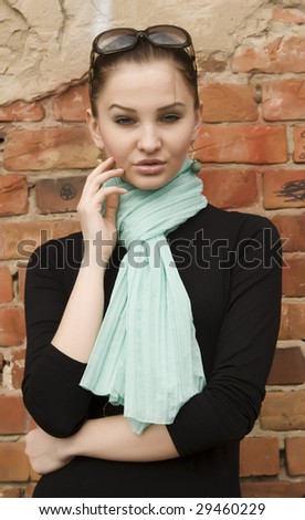 young pretty woman near brick wall