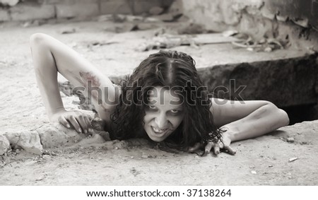 scary woman creeping out of a hole