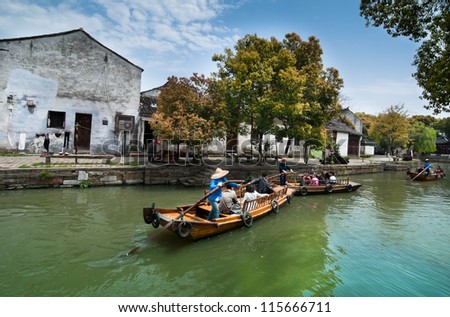 SUZHOU,CHINA - APRIL 17 : Many tourists go sightseeing around the ancient water town by the traditional row boat on April 17,2010 in Tongli water town of Suzhou City, Jiangsu Province, China.