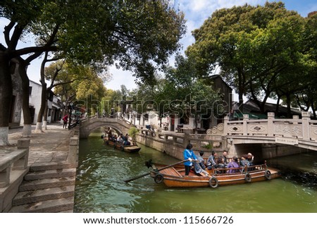 SUZHOU,CHINA - APRIL 17 : Many tourists go sightseeing around the ancient water town by the traditional row boat on April 17,2010 in Tongli water town of Suzhou City, Jiangsu Province, China.
