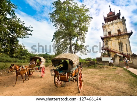 INWA,MYANMAR-DEC 1 : Tourist take horse cart to visit Nanmyin watchtower one of the famous travel destination on Dec 1,2012 in Inwa or Ava ancient city, Mandalay Myanmar.