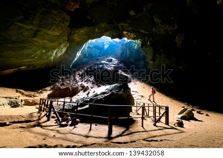 Female explorer and the light of heaven inside Phuphapetch cave , Satun Thailand