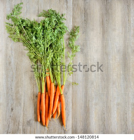 fresh and colorful natural carrots on wooden background