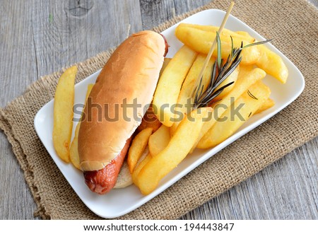 rustic big potatoes slice fried with rosemary aroma herbs and hot dog