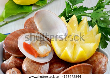 raw sea fruits called fasolari live again with lemon