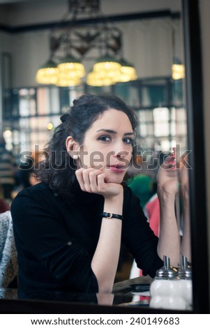 Young woman smoking in a stylish old European cafe
