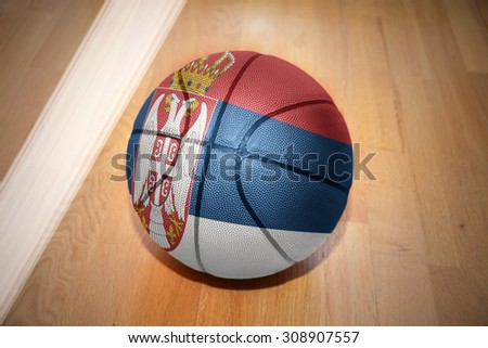 basketball ball with the national flag of serbia lying on the floor near the white line
