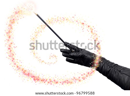 Magician hands in long black gloves holding magic wand and casting spell