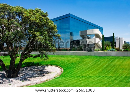 Business building near a green field in a clean blue day.