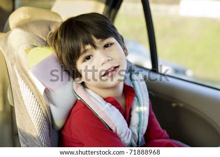 Four year old boy with cerebral palsy sitting in carseat