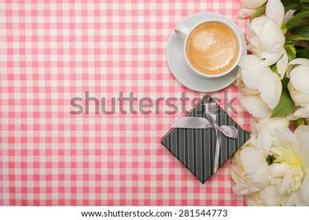 Gift box and a bouquet of peonies on a pink background