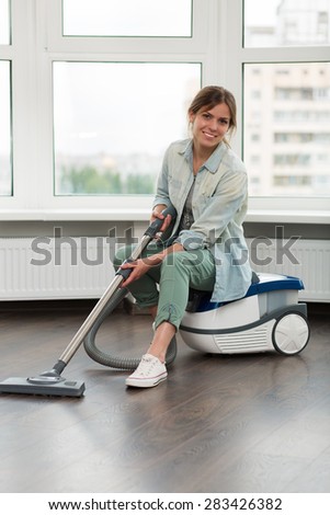 Beautiful young girl cleaning up her house