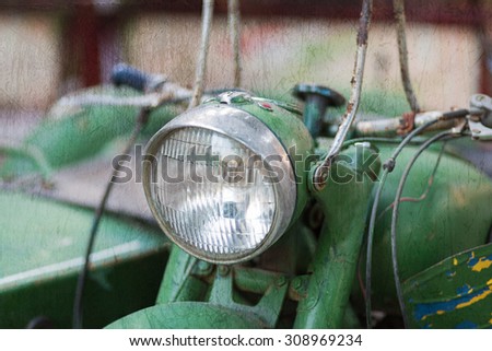 Green vintage motorbike headlamp. Textured image