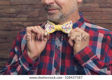 Bearded man holding a colorful bow tie