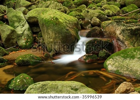 Calm brook with cascade on big stones