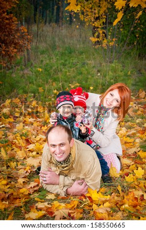 Family of four lying on the grass in the form of a pyramid