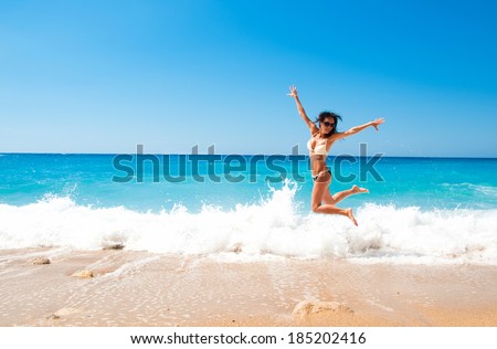 Cute brunette woman jump at sea