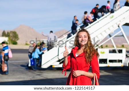 Happy your woman near the airship before on boarding in red coat