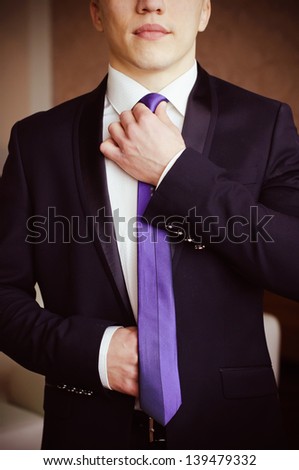 Man in black suite with half look of face
