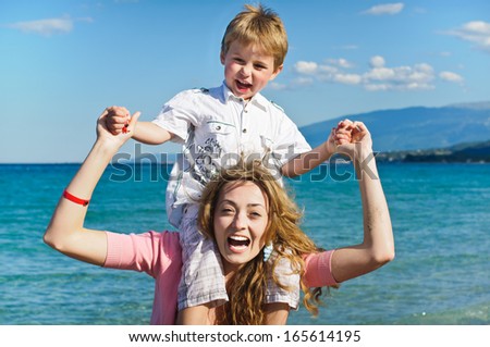 Mother giving son a shoulder ride at the beach