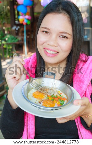 Asia girl eat Egg pan in restaurant.