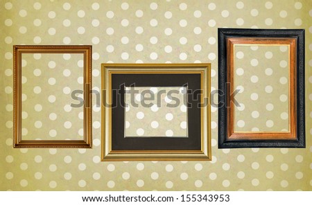Beautiful blank ancient frames on a retro dotted wall