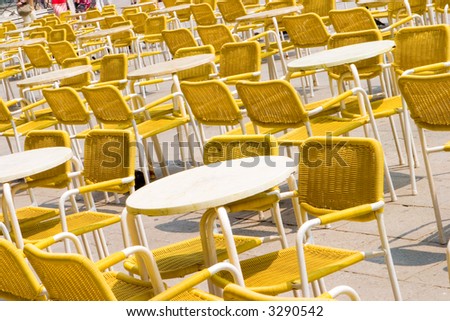 Empty tables and chairs in the sun
