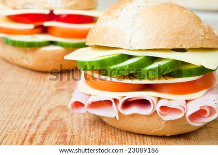 Delicious ham, cheese and salad sandwich on a wooden board