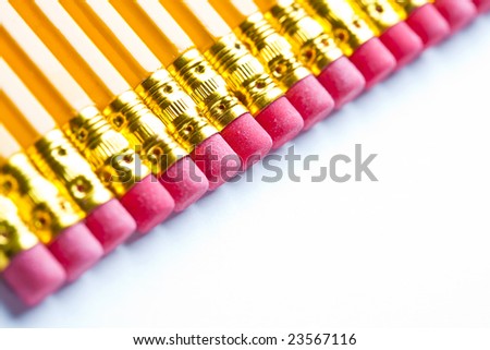 Yellow pencils with a rubber on the end in a straight line