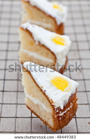 Three slices of delicious lemon sponge cake on a cooling tray