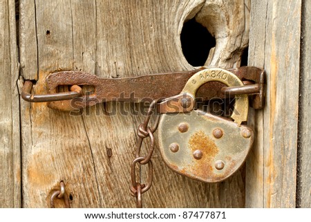 Close up of old fashioned antique lock on a worn wooden door.