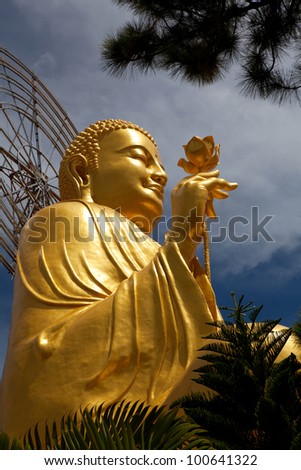 Golden Buddha holding the golden lotus from the up angle