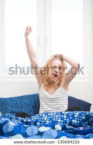 caucasian woman in bed, getting up late to work with terrible hangover, funny concept