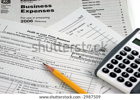IRS Business Tax forms with pencil and calculator