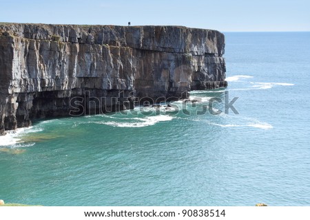 Two people stand alone on the cliff top - the world is their oyster