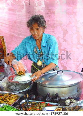 BANGKOK, THAILAND - MAY 1, 2008: Old Thai woman displays hot rice at the market