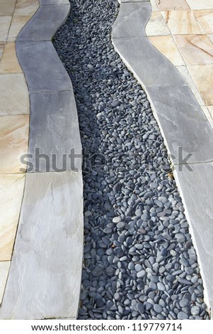 a garden patio design with slabs and pebbles
