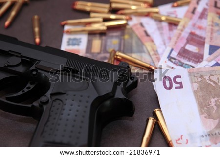 a stash of drugs gun and money showing a dangerous cost to life against a dark background