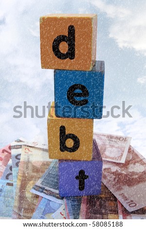 assorted childrens toy letter building blocks against a stormy background on money that spell debt