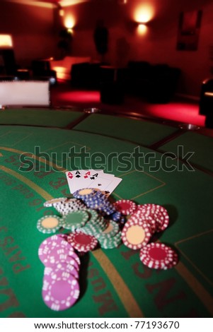 green casino table four aces in a poker game and a big pile of chips