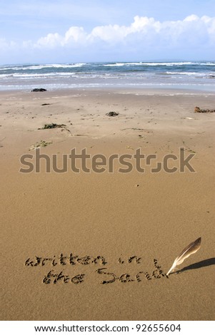 a feather used as a quill pen to write written in the sand on an irish coastal beach