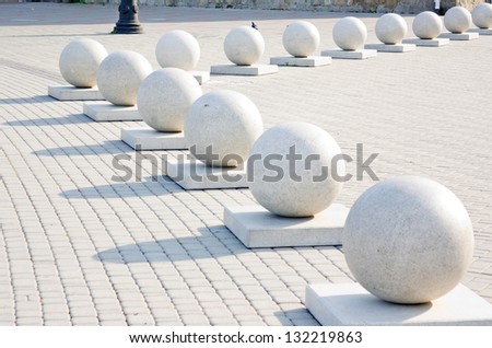 Protection in the form of decorative stone spheres on sidewalk