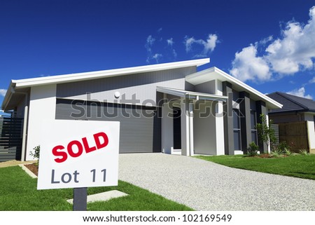 New suburban Australian house with large SOLD sign.