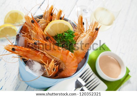 Bucket Of King Prawns On Ice With Lemon, Sauce And Two Glasses Of Wine ...