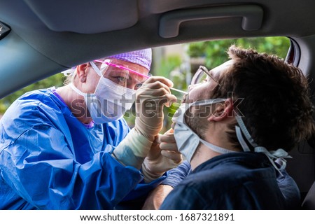 A doctor in a protective suit taking a nasal swab from a person to test for possible coronavirus infection Foto stock © 