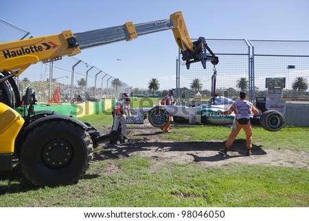 MELBOURNE, AUSTRALIA - MARCH 17 Michael Shumacher helps remove his car after he runs wide and gets stuck in the gravel trap at turn 9 on March 17, 2012 in Melbourne, Australia