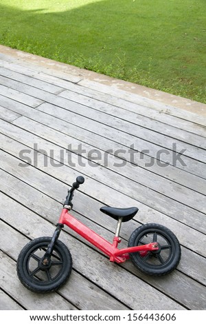 Red bike for kid on wooden floor