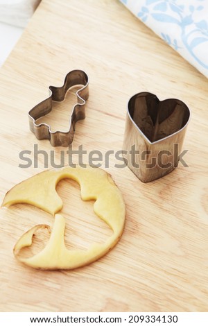 Heart shape and girl shape mold on wooden board for making potato chip